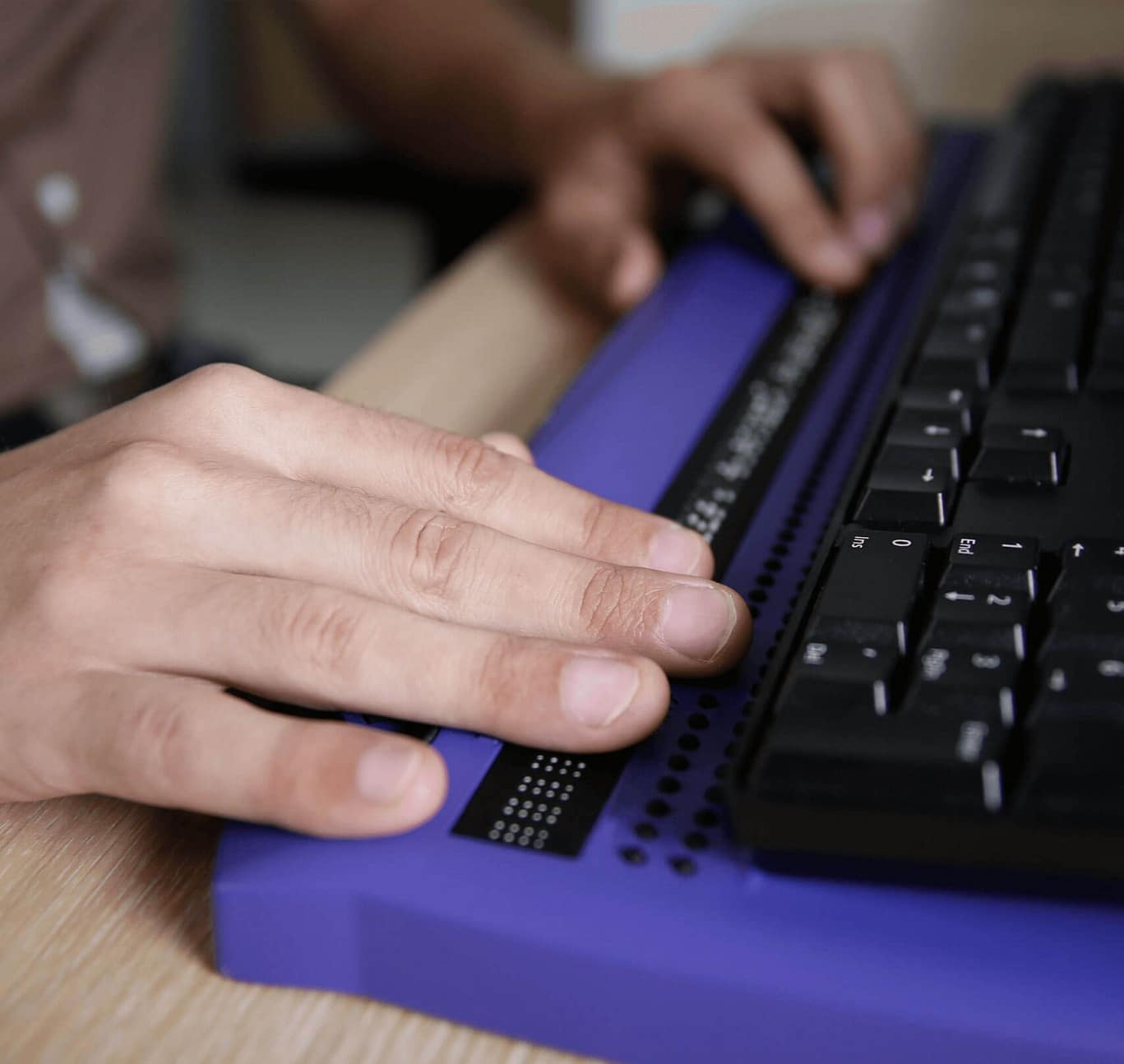 Person Using a Braile Device on a Keyboard
